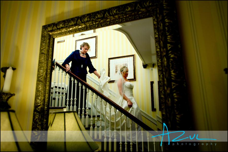 Photograph of bride descending down stairs as she heads to her wedding in Wilson, North Carolina. The photographer framed the bride in a mirror.