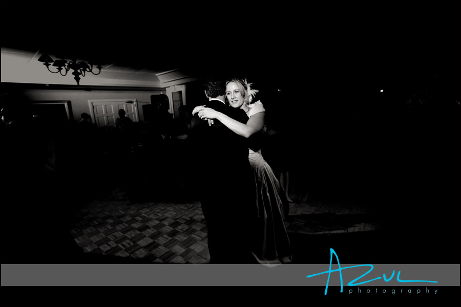 The bride holds on to her husband as they embrace on another on the dance floor.